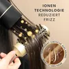 A close-up shot of a person using a hairdryer on their hair, with animated elements representing ions and hair care. Produktbild-Vorschau