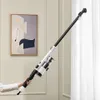 A person is holding a cordless vacuum cleaner in a room with a painting on the wall and white curtains. Produktbild-Vorschau