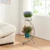 A plant stand with two potted plants next to a sofa and a window. Náhľad obrázku produktu