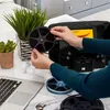 A person is using a Kodak film digitizer to convert old film reels to digital format, with a laptop and SD cards nearby. Produktbild-Vorschau