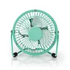 A teal desk fan with a white grill and blades, on a reflective white surface. Podgląd zdjęcia produktu