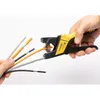 A hand is using a yellow and black wire stripper to strip the insulation off an orange wire, with several other wires held in the other hand. Anteprima dell’immagine prodotto