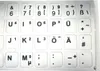 A close-up view of a sheet of silver keyboard stickers with black text and symbols. Produktbild-Vorschau