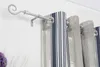 A close-up view of a silver curtain rod with a decorative swirl end, holding striped curtains. Produktbild-Vorschau