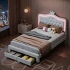 A bedroom scene at night with a bed, nightstand, and window view of a city skyline. Voir les images du produit