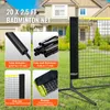 A badminton net set displayed outdoors in a grassy yard with a house in the background. Produktbild-Vorschau