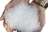 Hands holding a pile of small white plastic pellets. Podgląd zdjęcia produktu
