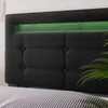 A close-up view of a dark grey upholstered headboard with integrated green LED lighting. Voir les images du produit