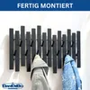 A black metal wall coat rack with multiple hooks, displaying two jackets hanging on it. The background is a plain white wall. Produktbild-Vorschau