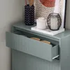 A close-up view of a light gray shoe cabinet with an open drawer, revealing some bowls inside. Decorative items are placed on top of the cabinet. Anteprima dell’immagine prodotto
