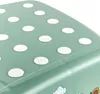 A close-up view of the top surface of a green step stool with white polka dots. Produktbild-Vorschau