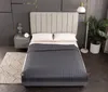 A neatly made bed with a gray weighted blanket and white pillows, set in a modern bedroom with a nightstand and a floor lamp. Podgląd zdjęcia produktu