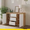 A modern sideboard with drawers and doors, decorated with a lamp, picture frame, and vases. Voir les images du produit