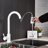 A person's hand is operating a white pull-out kitchen faucet over a sink. Náhľad obrázku produktu