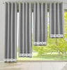 Several gray curtains of different sizes are displayed in front of a window with a view of a tree and greenery. Produktbild-Vorschau