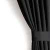 A black curtain is shown draped against a white wall, held by a fabric band. Produktbild-Vorschau