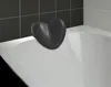 A black heart-shaped bath pillow rests on the edge of a white bathtub. Podgląd zdjęcia produktu