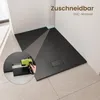 A black shower tray is shown in a bathroom corner, with a close-up inset showing a hand using a tool to cut the tray. Náhľad obrázku produktu