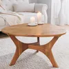 A wooden coffee table with two candles on it, placed in a living room setting with a sofa in the background. Produktbild-Vorschau