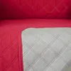 A close-up view of a quilted sofa cover, showing the red quilted fabric and the gray backing. Produktbild-Vorschau