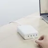 A white multi-port charger is plugged into a laptop on a wooden desk. Voir les images du produit