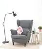 A plush bunny sits on a gray armchair next to a floor lamp and small side tables. Náhľad obrázku produktu