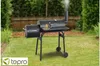 A black Tepro Smoker-Grill Wichita is set up on a green lawn in a backyard setting. Produktbild-Vorschau