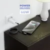A white USB-C charger plugged into a wall socket, connected by a black and white braided cable to a smartphone that is charging on a dark wooden nightstand next to a white lamp. Produktbild-Vorschau
