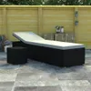 An outdoor patio scene with a black rattan sun lounger and a small black cube table. Náhľad obrázku produktu