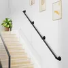 A black metal handrail is installed along a staircase against a white wall, with framed artwork hanging above. Produktbild-Vorschau