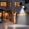 A modern house exterior at night, with a driveway, garage, and entrance illuminated by outdoor lighting. Produktbild-Vorschau
