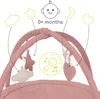 Close-up of a baby activity gym with hanging toys and illustrations of baby-related icons. Produktbild-Vorschau