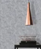 A close-up shot of a textured gray wallpaper with a copper pendant light and a copper wire bowl on top of books. Produktbild-Vorschau
