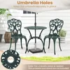 A green metal bistro set with two chairs and a table on a patio, with an umbrella in the table. Náhľad obrázku produktu