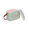 A retro-style cooler box with its lid open, showing the interior and a strap attached. Produktbild-Vorschau