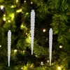Three clear acrylic icicles are hanging on a blurred green Christmas tree with yellow lights. Podgląd zdjęcia produktu