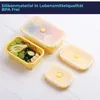 Several yellow silicone food containers are arranged on a light-colored surface. One container is filled with a salad, another with food, and two are empty with lids on. Podgląd zdjęcia produktu
