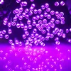 A close-up, low-angle shot of a string of purple LED lights, some of which are reflecting on a surface below. Produktbild-Vorschau