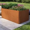 A large, rectangular Corten steel planter filled with plants and flowers, placed on a concrete patio next to a lawn. Produktbild-Vorschau