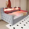 A grey upholstered daybed with built-in LED lighting and storage drawers, shown in a bedroom setting with a rug and artwork. Voir les images du produit