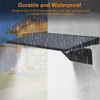 A solar wall light is mounted on a wall with rain falling. Produktbild-Vorschau
