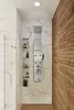 A modern shower stall with a stainless steel shower panel, marble walls, and a wooden accent wall. Podgląd zdjęcia produktu