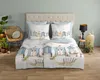 A neatly made bed with a duvet cover featuring a print of beach houses. Produktbild-Vorschau