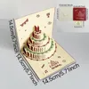 A pop-up birthday card with a tiered cake design is shown open, with a smaller envelope and card set displayed in the upper right corner. Podgląd zdjęcia produktu
