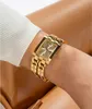 A woman's arm wearing a gold Guess watch. Náhled obrázku produktu