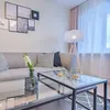 A modern living room scene with a sofa, coffee table, and lamp. Anteprima dell’immagine prodotto