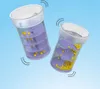 Two transparent containers with purple spiral inserts and yellow balls inside, against a light blue background. Produktbild-Vorschau