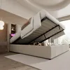 A bed with its storage compartment open, revealing items stored inside. The bed is in a room with soft lighting and a window in the background. Produktbild-Vorschau