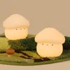 Two mushroom-shaped night lights are placed on a green, textured surface that resembles grass and dirt. Podgląd zdjęcia produktu