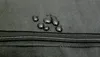Water droplets on a black fabric surface next to a zipper. Náhled obrázku produktu